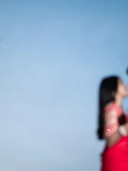 A creative focus technique draws the eye to the distant plane and the modern architecture, while the couple remains a soft, intimate presence. This is an example of our artistic approach to pre-wedding photography.