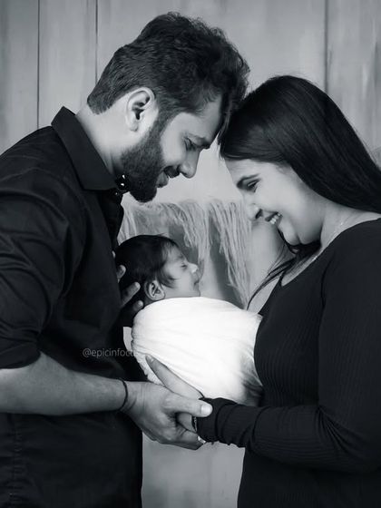 A classic black and white family portrait showing parents lovingly gazing at their newborn. This style creates a timeless and elegant memory of your family's beginning.