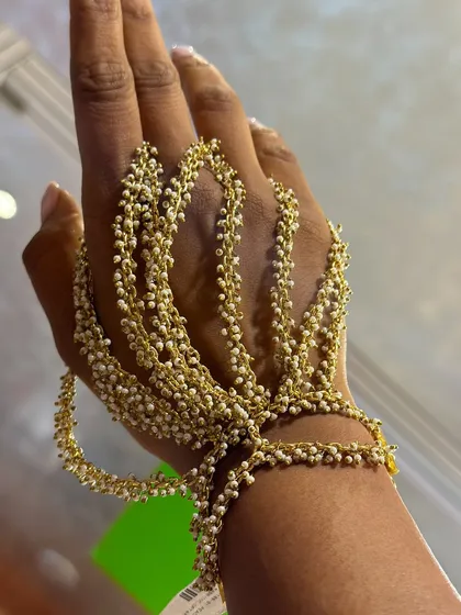 A close-up of our bestselling pearl hand harness. I designed this piece to be delicate yet make a statement, with cascading strands of tiny pearls that beautifully adorn your hand for any festive occasion.