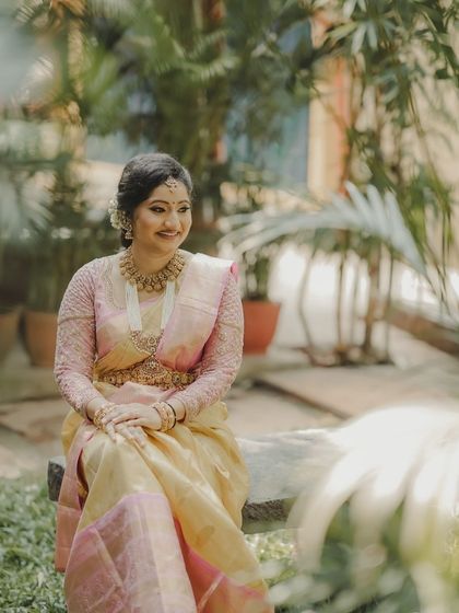 A happy and serene portrait of Vaishnavi, enjoying her special day in our tissue silk saree.