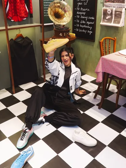 A fun, playful shot of me on the floor surrounded by different colorways of the Puma Palermo sneakers.