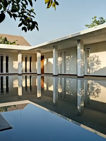 The spa complex at the Club Mahindra Lake Pawana Resort. Here, a still, expansive body of water acts as the central element, reflecting the clean lines of the surrounding colonnade and exuding a profound sense of serenity and calm, essential for a space dedicated to wellness.