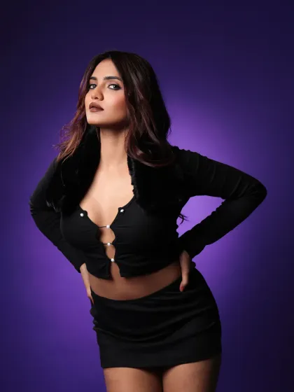 A full-body shot from the 'aera' shoot, showing the model owning the frame. The lighting on the purple backdrop makes the black outfit stand out.