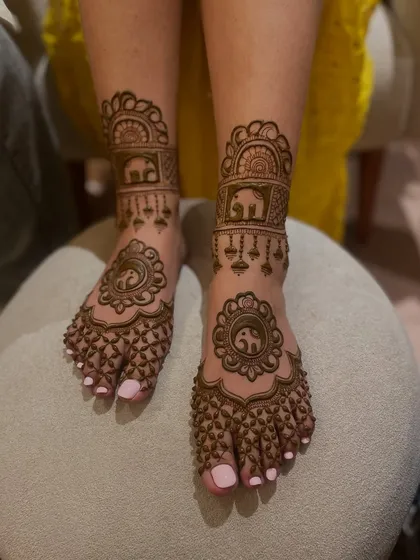 An adorable foot mehandi design featuring small elephant motifs on the feet and ankles.