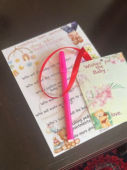 A set of my baby shower game cards and wish tags, complete with a pen for guests to use.