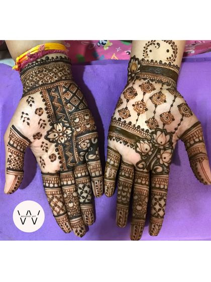 A unique, mismatched design for a guest, with one hand featuring a patchwork pattern and the other with hanging motifs.