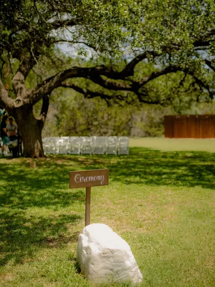 A charming detail shot of the "Ceremony" sign, setting the scene for a rustic, outdoor wedding in Texas.
