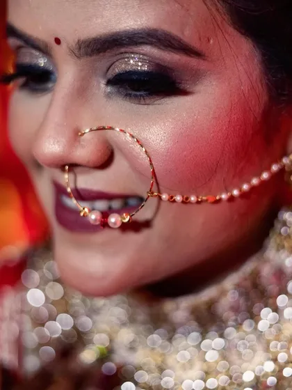 A detailed close-up of a bride's face, highlighting her beautiful pearl-adorned nath (nose ring) and sparkling eye makeup. I focus on these small details to create stunning and intimate bridal portraits.