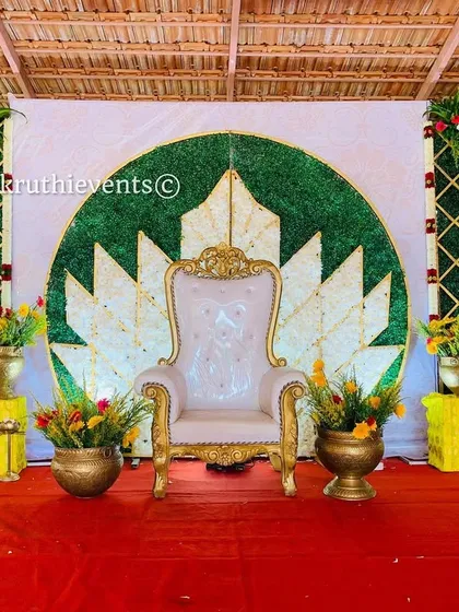 A beautiful lotus-themed backdrop for an outdoor event. The central motif is made of white and gold leaves against a green background, creating a natural and serene setting.