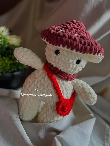 This whimsical mushroom-man plushie is made from soft chunky yarn and features a little red bag. It's a unique character toy that sparks imagination.