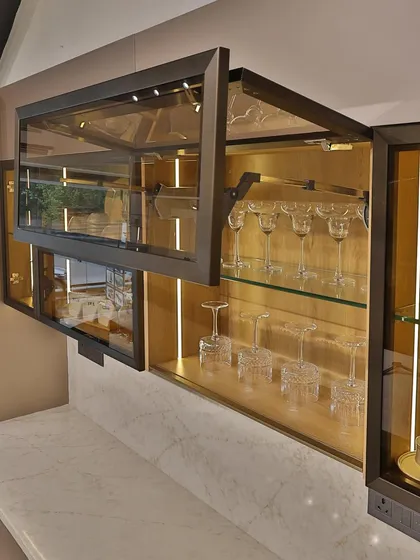 This shot showcases the lift-up glass cabinet doors, a modern alternative to traditional swinging doors. They provide easy access to glassware while adding a sleek, contemporary touch.
