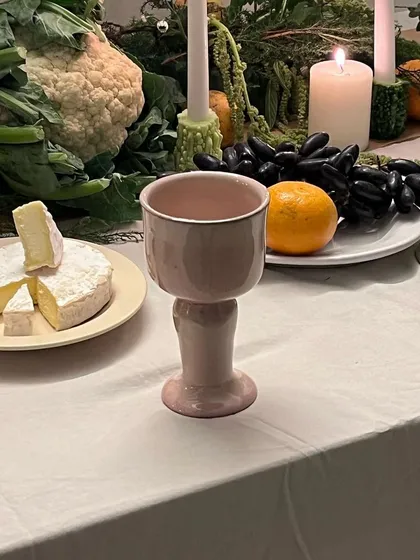 The 'Kāge' goblet, with its soft pink hue, is a perfect complement to the warm candlelight. These pieces are designed to bring joy to your life.