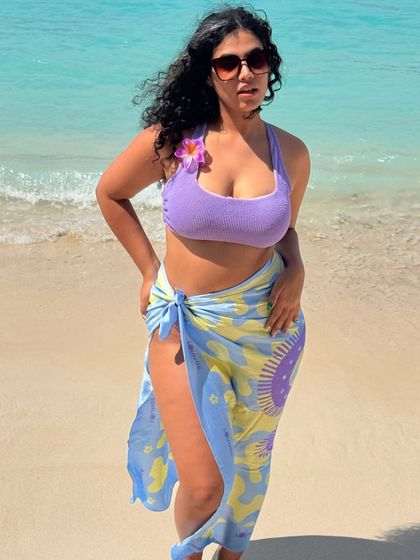 Summer in Bali. A classic beach pose in a lilac bikini and a colorful sarong, with the crystal clear water of the Gili Islands behind me.