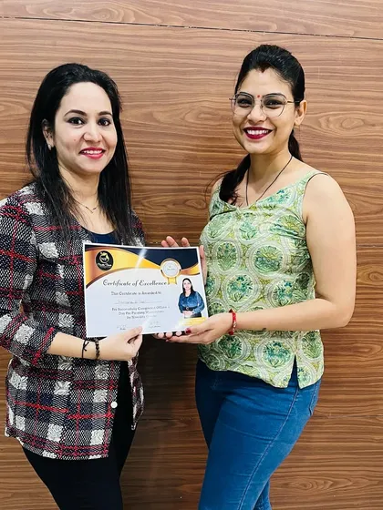 Another student proudly holding her certificate after completing our saree masterclass.