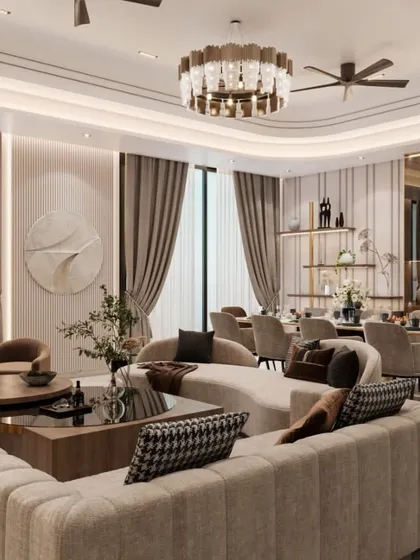 A wide shot of the living and dining area, showcasing the curved sofa and elegant chandelier. The design uses a neutral palette with touches of brown and black to create a sophisticated and harmonious environment.