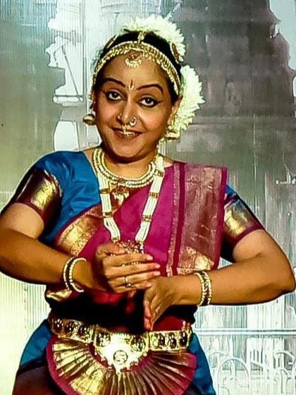 A close-up of a senior Bharatanatyam artist, Ms. Deepa Menon, showcasing the detailed 'aharya' or costume and makeup.