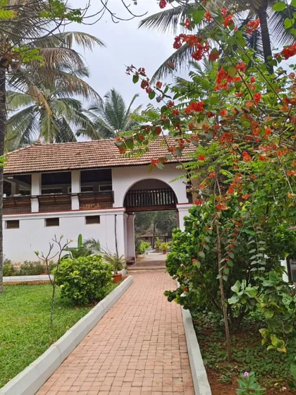 The pathway leading to the Padipura, framed by blooming flowers and lush greenery. Every walk on our campus is an opportunity to connect with the beauty of nature and the history embedded in our architecture.