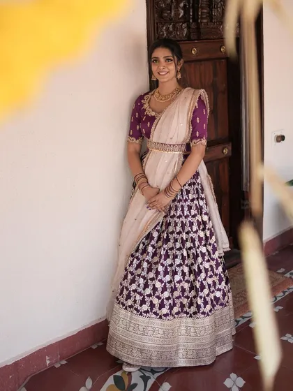 A client looking elegant in our purple brocade lehenga, paired with a cream dupatta and a statement belt.