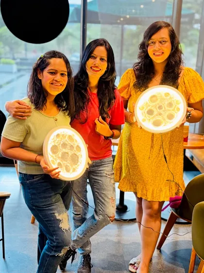 A trio of friends with their finished, glowing moon lamps. It's a fantastic group activity, and everyone leaves with a stunning, functional piece of art.