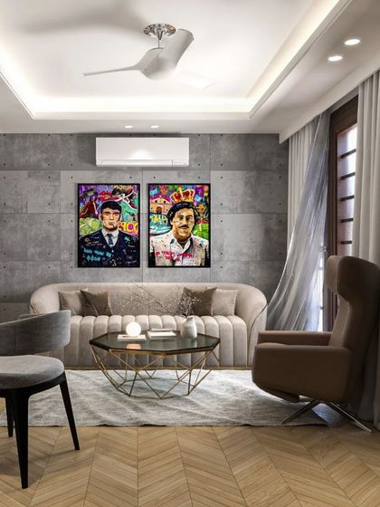 This living room design has an urban, industrial feel, with a concrete-textured wall and bold pop-art prints. The herringbone wood floor and comfortable, modern furniture balance the look, making it feel like a stylish city apartment.