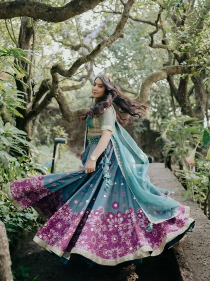 A whimsical shot from a pre-wedding function. The client is wearing a beautiful blue and purple lehenga, and I created a soft, natural makeup look to match the outdoor setting.