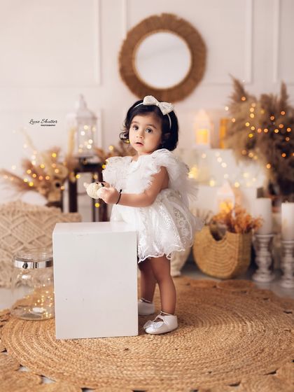 A little explorer! This shot captures the new mobility and curiosity of a one-year-old during her birthday photoshoot.