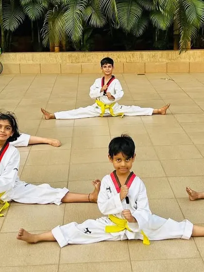 A group of our young students showing off their middle splits, a result of consistent stretching and hard work.
