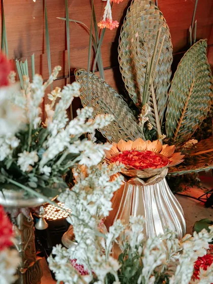 A close-up of the decor, featuring woven palm leaves and white rajnigandha flowers for a natural, textured look.