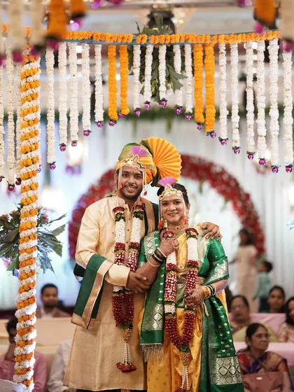 A beautiful portrait of the bride and groom under the mandap. Their traditional outfits and her radiant makeup create a perfect wedding picture.