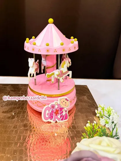 The charming pink musical carousel is a standout piece that makes this hamper a magical keepsake.