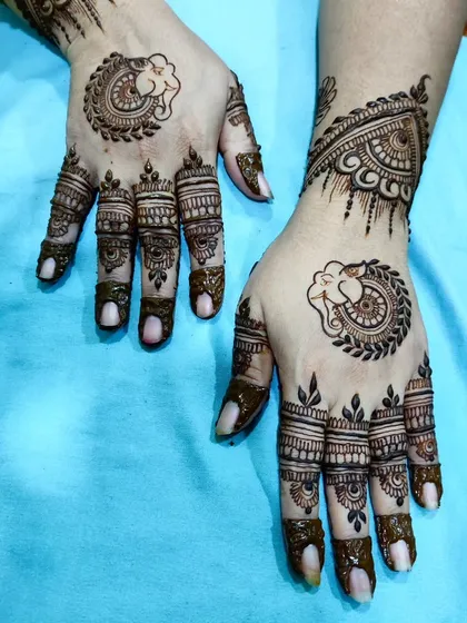 Here, the Ganesha motif is incorporated into a larger design, framed by a mandala and detailed finger work.