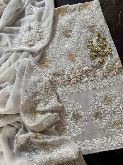 A draped view of the suit with traditional earrings, suggesting a complete look.