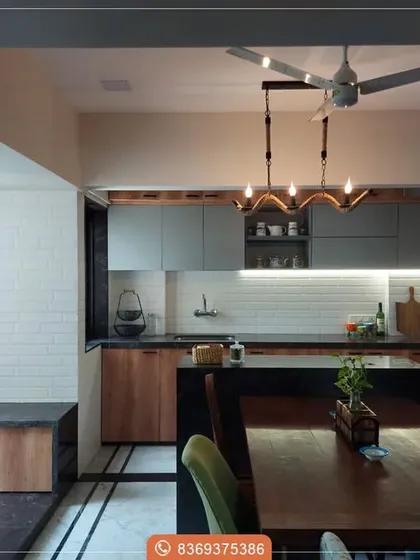An open-concept design that blends the kitchen with the dining area. The combination of warm wood and cool grey cabinetry, paired with a white subway tile backsplash, creates a modern yet cozy and inviting environment.