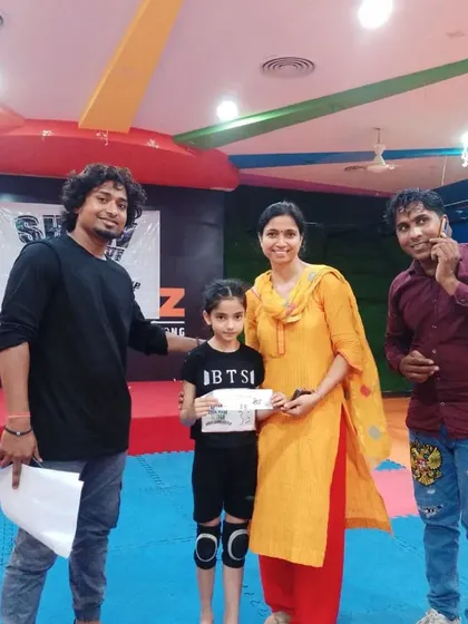 A young student, accompanied by her mother, receives her selection certificate. We value the support of families and work together to help our dancers succeed.