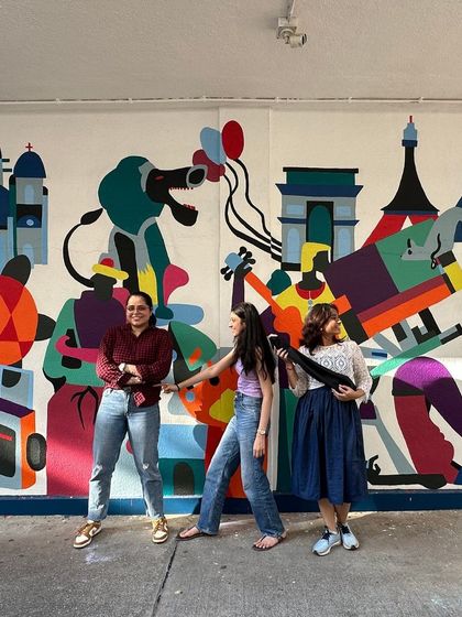 A playful moment with collaborators in front of the festival mural.