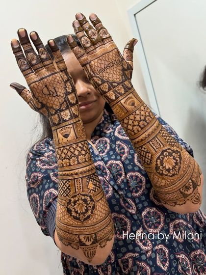 A stunning full-arm bridal mehendi with dense, traditional patterns. The design covers the hands completely, creating a rich and classic look for the bride.