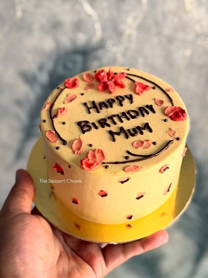 A lovely Lotus Biscoff mini cake, held in hand to show its cute, personal size. Perfect for celebrating your mum's birthday in a small, intimate way.