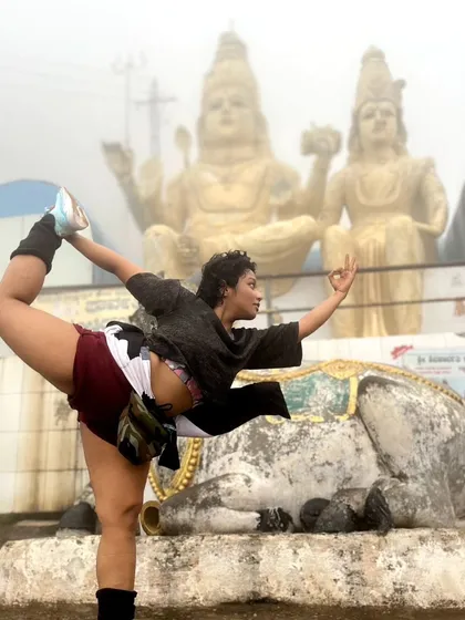 Taking my practice outdoors connects me to a deeper spiritual energy. This is me in Natarajasana (Dancer's Pose) at Shivagange, finding balance and devotion amidst the fog and ancient statues.
