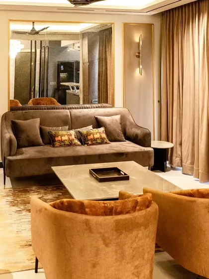 This living area demonstrates our skill in layering textures and colors. We combined sofas in different rich tones, a hide rug, and a large mirror with a gold frame to create a space that feels both glamorous and inviting.