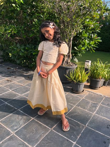 A timeless classic with a modern twist. This cream checkered two-piece set features a flowy skirt and a comfortable top with an adorable bow detail on the back.