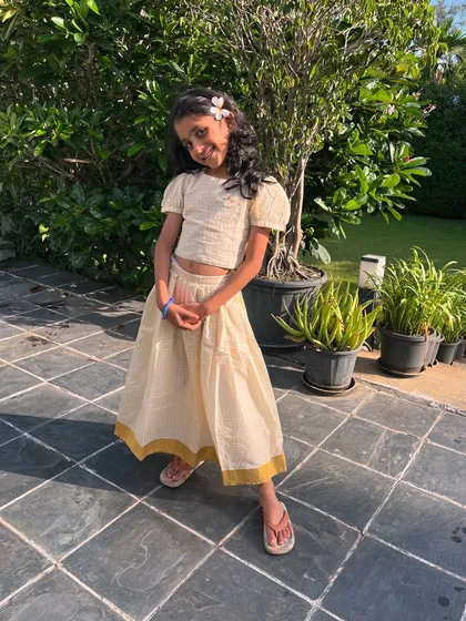 A timeless classic with a modern twist. This cream checkered two-piece set features a flowy skirt and a comfortable top with an adorable bow detail on the back.