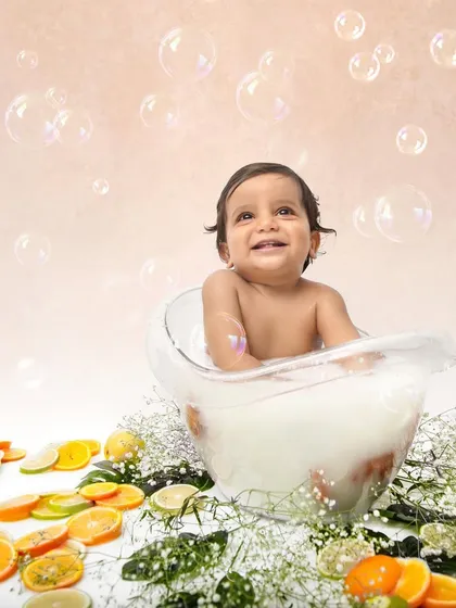 A milk bath session is a unique and fun way to celebrate a first birthday. Surrounded by bubbles and citrus slices, this little one's happy expression is absolutely priceless.