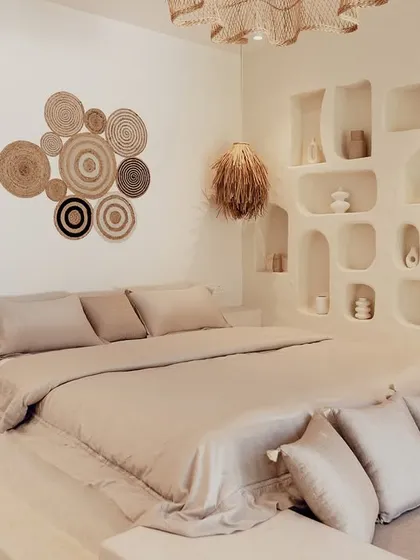 In this bedroom at the Artha Villa, I created a tranquil retreat using earthy textures and a neutral color scheme. The built-in platform bed and organic-shaped wall niches are custom architectural details that make the space feel like a serene, personal nest.