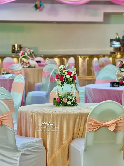 Elegant guest seating with peach-colored linens and chair bows, complemented by delicate floral centerpieces.