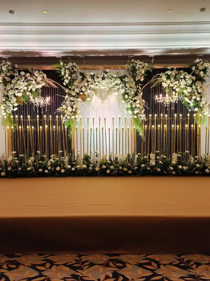 A full view of the candle-lit reception stage, showcasing the grand scale of the floral arrangements and the dramatic effect of the lighting.