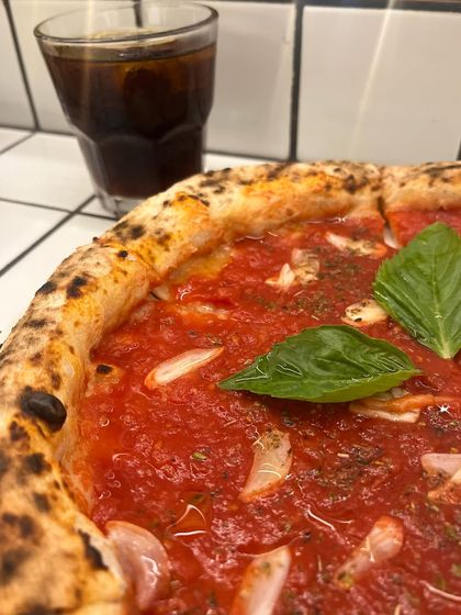 A close-up of our Marinara pizza with an iced coke. The vibrant red of the tomato sauce is just beautiful.