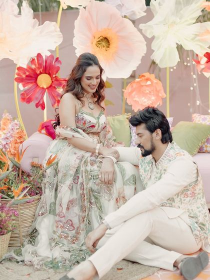 A candid moment of connection between the couple. Janvi's soft glam makeup looks beautiful in the natural light of her outdoor Mehndi ceremony.