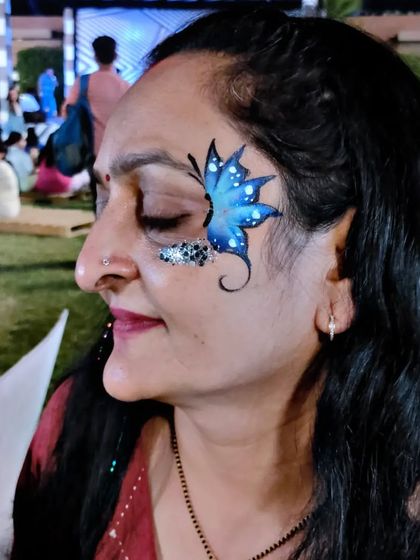 Another happy client with a blue glitter butterfly design, perfect for an evening event.