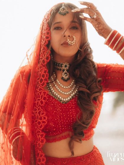 A confident and stylish bridal portrait. The way she holds her veil adds a touch of drama and elegance to the shot.