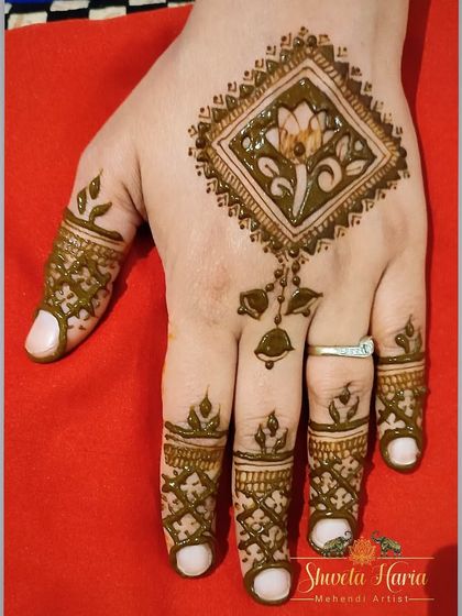 A simple and elegant henna design perfect for any occasion. This piece features a single diamond-shaped floral motif on the back of the hand with delicate patterns on the fingers.